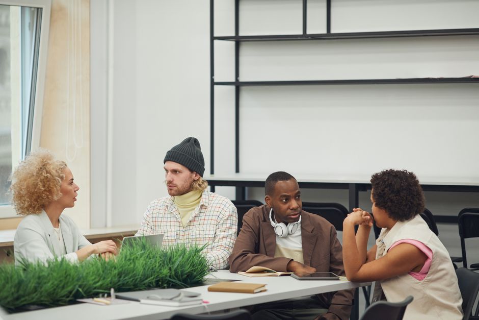 A diverse group of colleagues engaging in a collaborative meeting in a modern office setting.