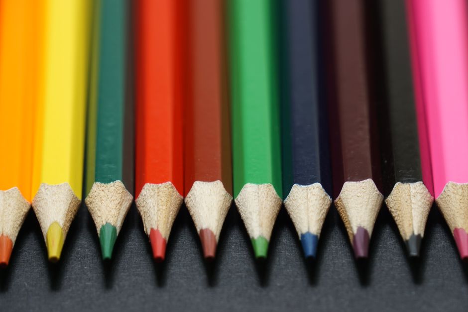 A vibrant set of colored pencils neatly arranged on a dark surface.