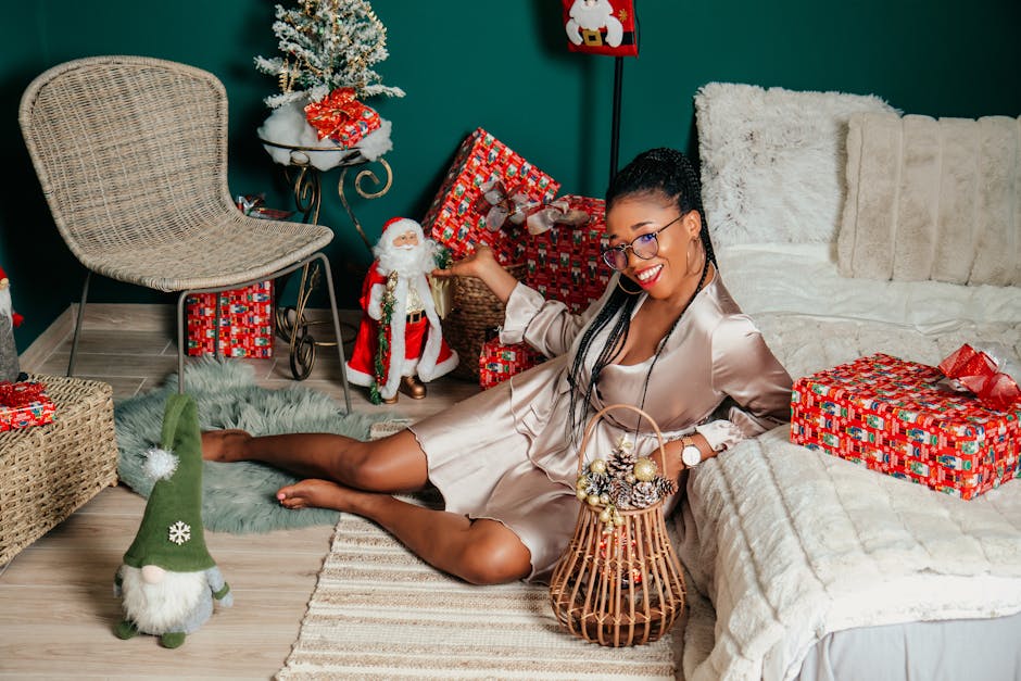 Woman in silk robe enjoying Christmas gifts in a cozy setting.