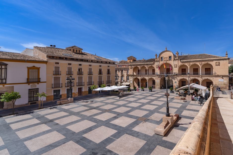 A sunny day in a historic plaza in Lorca, Spain showcasing traditional architecture.