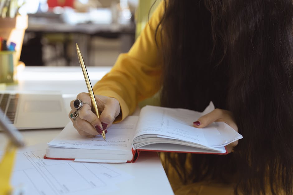 Close-up of a woman writing in a notebook, focusing on hand and pen, suitable for productivity themes.