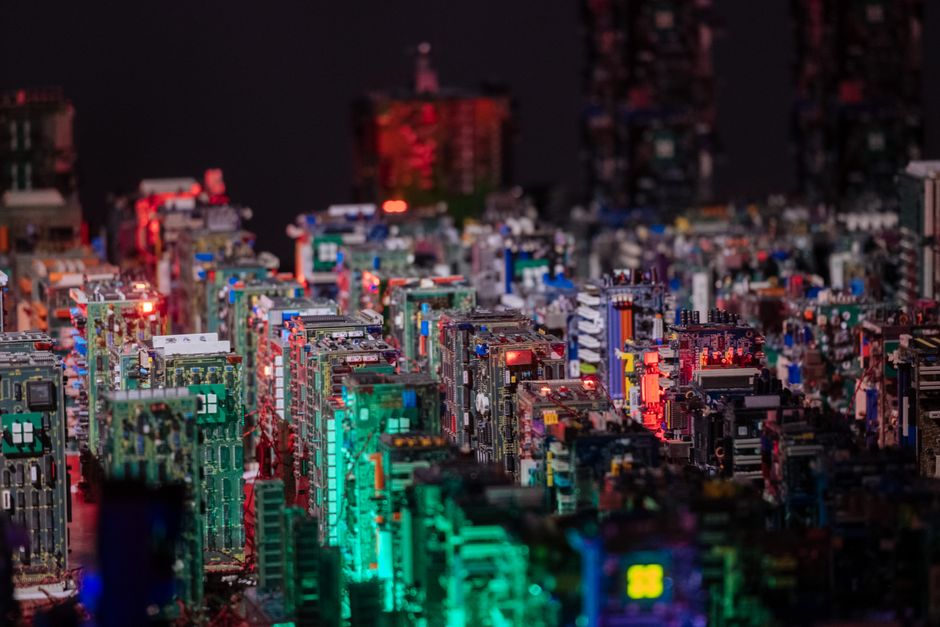 Nighttime cityscape made of illuminated PCB boards creating a futuristic science fiction feel.