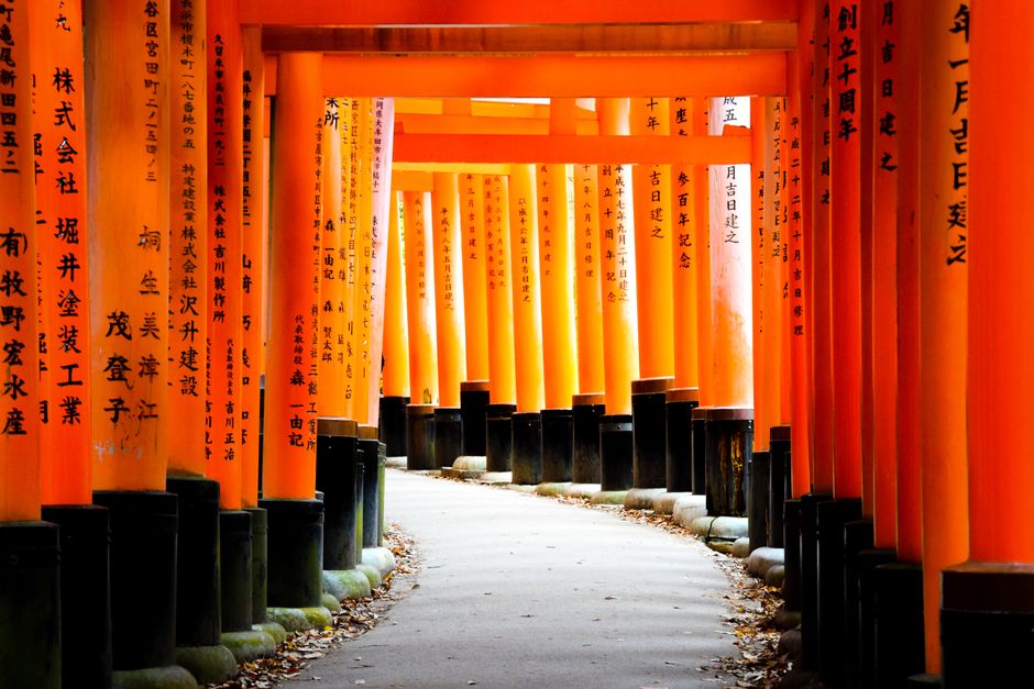 A pathway through the iconic orange torii gates of Fushimi Inari Shrine in Kyoto, Japan.