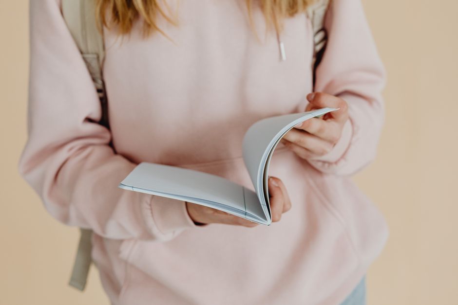 Close-up of a teenager holding a notebook, symbolizing back-to-school season.