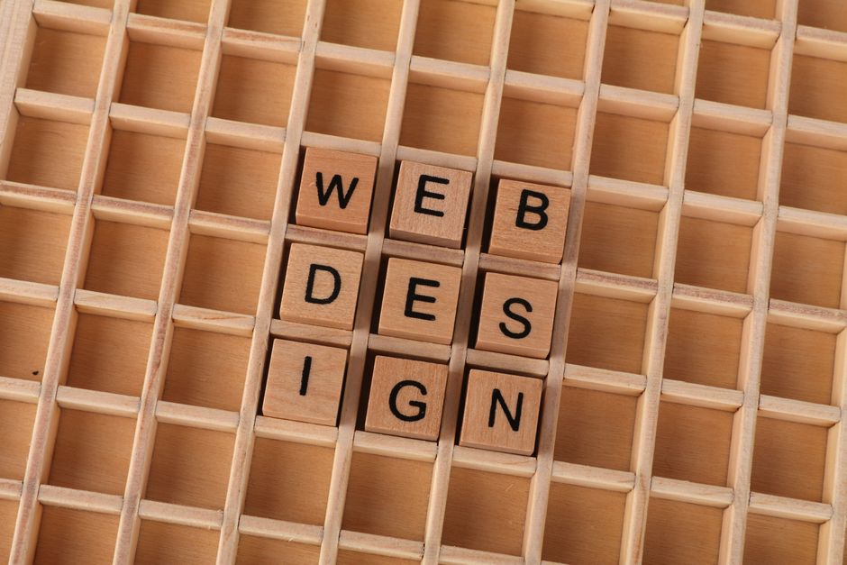Wooden blocks spelling web design on a grid background symbolizing creative digital design concepts.