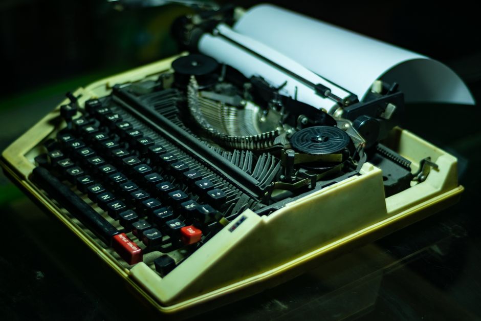 Close-up of an antique typewriter with paper, showcasing classic technology and nostalgia.